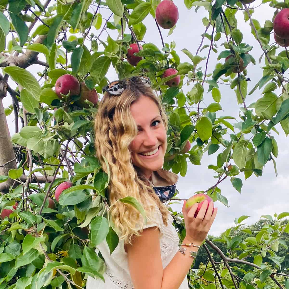 Rachael holding apple in apple tree.
