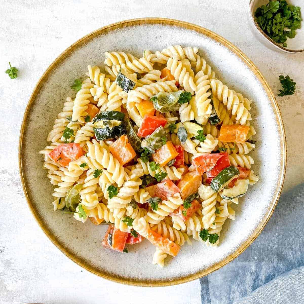 overhead shot of pasta salad with roasted veggies and topped with parsley.