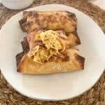 egg rolls on a plate with one cracked open so you can see the inside