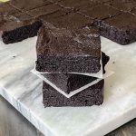 brownies stacked on white marble slab.