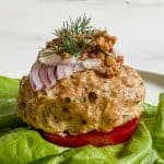 turkey burger on a lettuce wrap with toppings.
