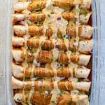 Pan of enchiladas with homemade dairy free cheese sauce on top.